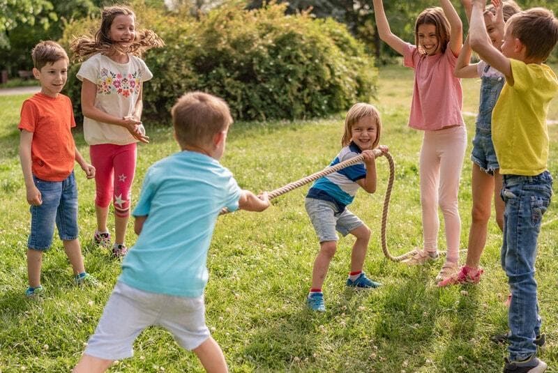 Barn som leker dragkamp i trädgården